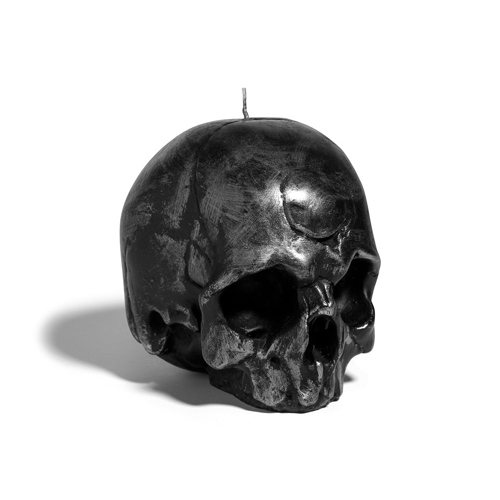 Black skull-shaped candle on a white background