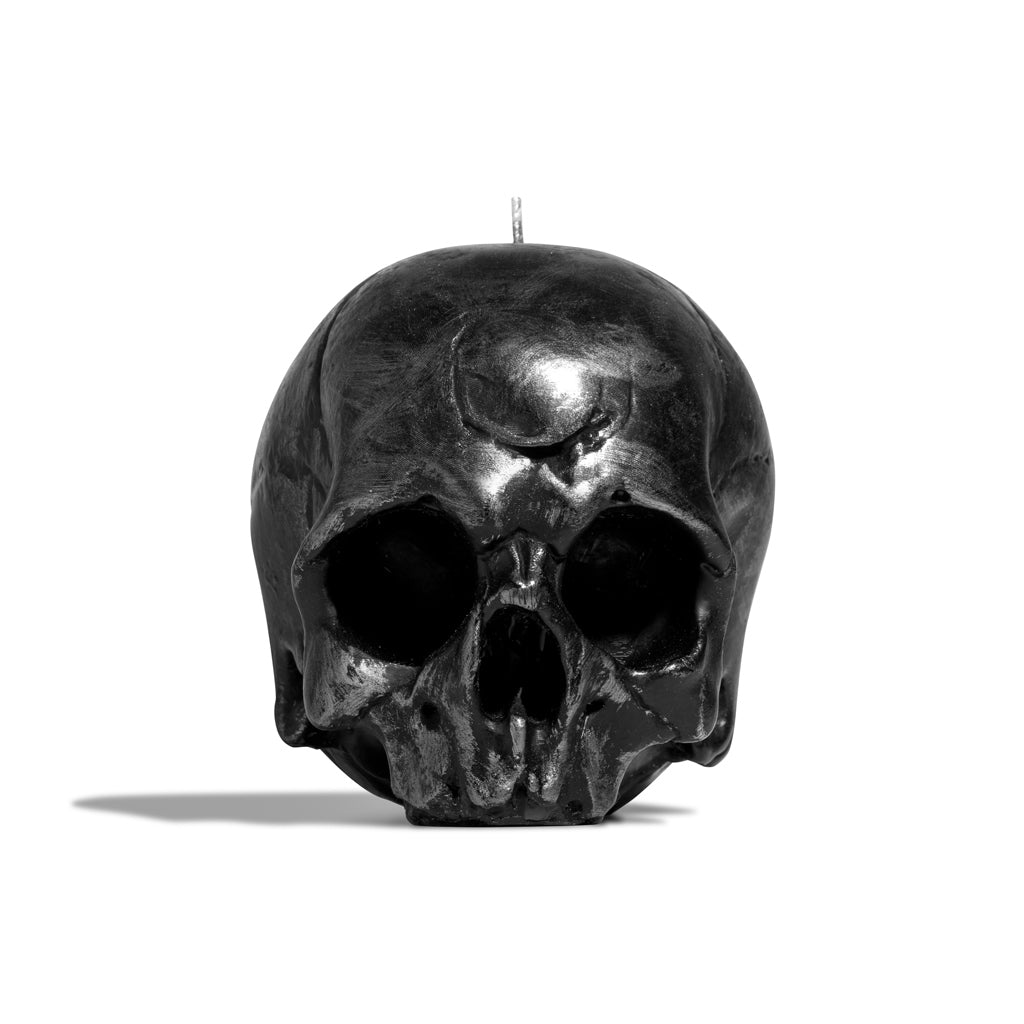 Momento Mori black skull-shaped candle on a white background