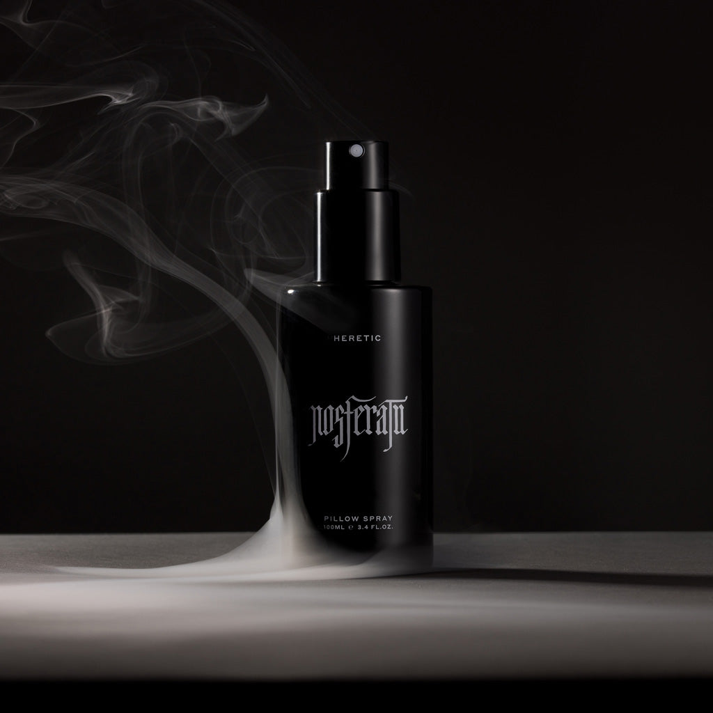 Black bottle of 'Heretic Nosferatu' pillow spray with smoke effect on a dark background