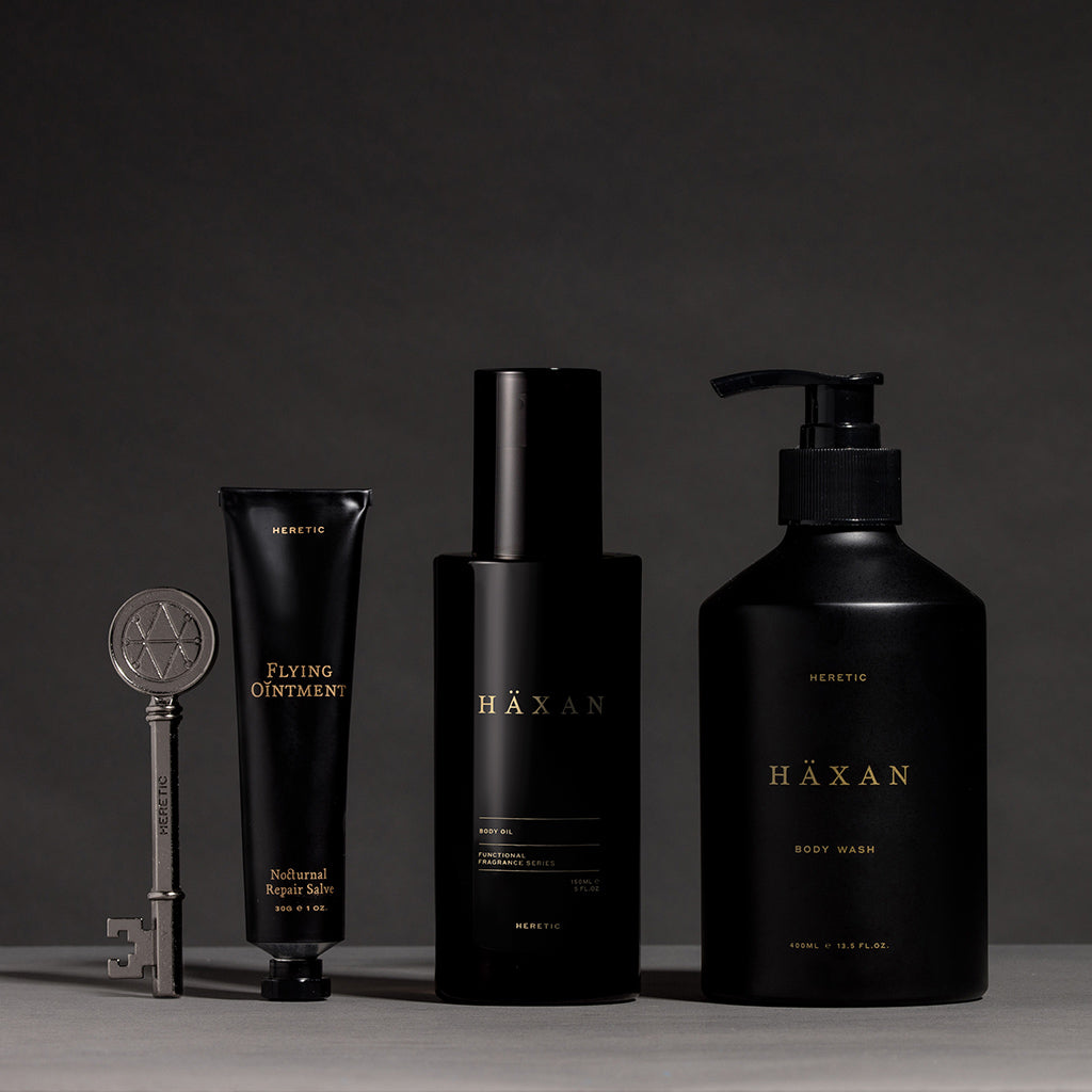 Three black cosmetic containers from HAXAN arranged on a dark studio background.